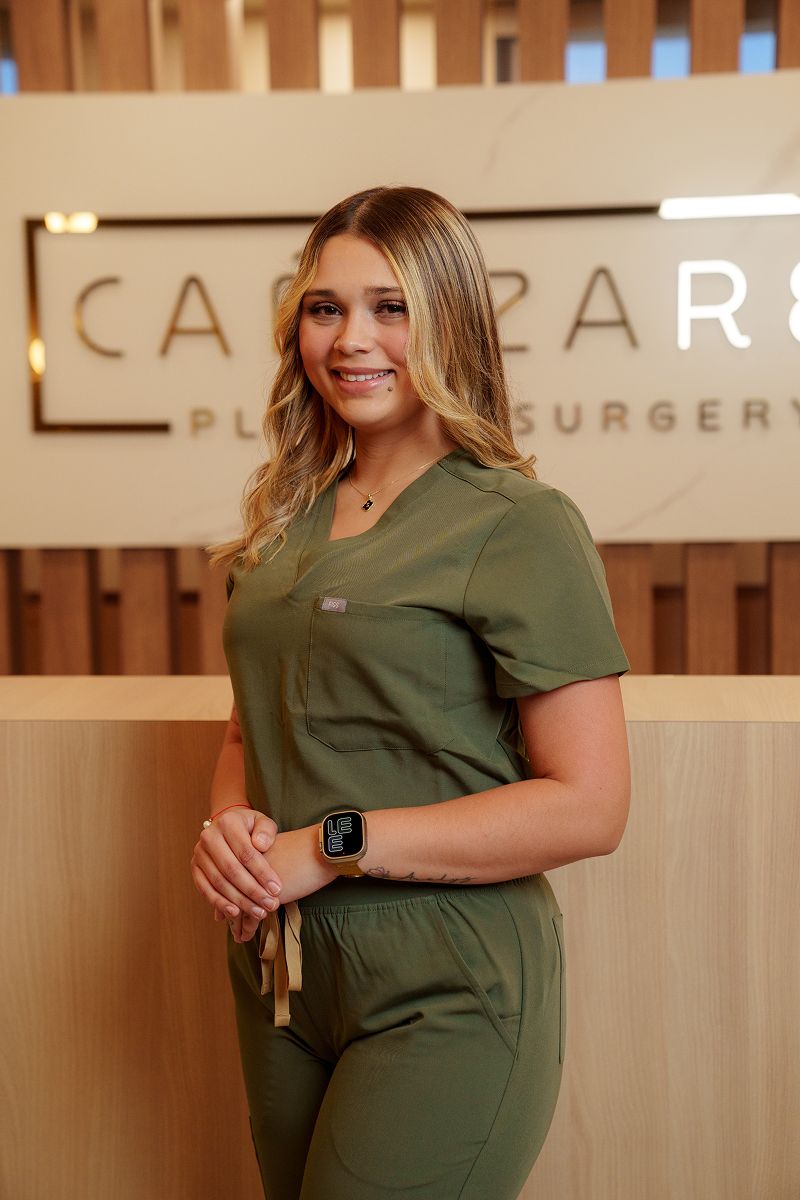 Smiling professional in medical attire, healthcare setting.