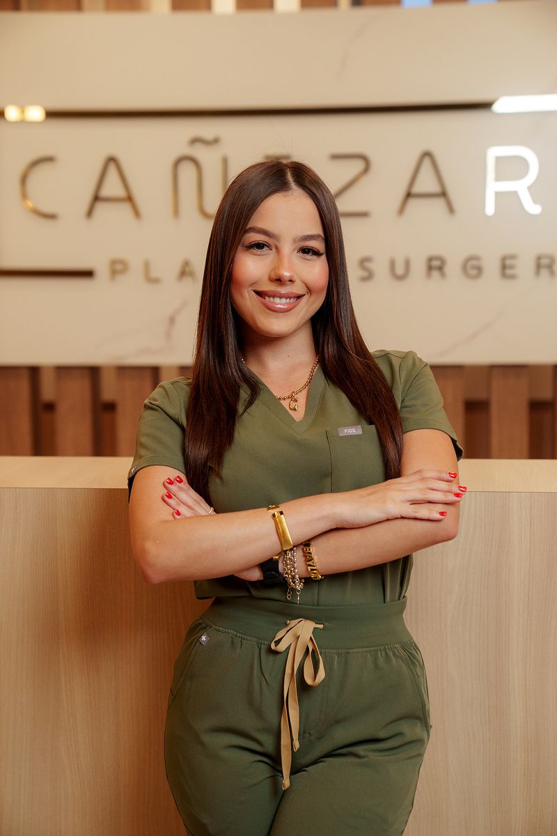 Smiling woman in medical scrubs, welcoming environment.