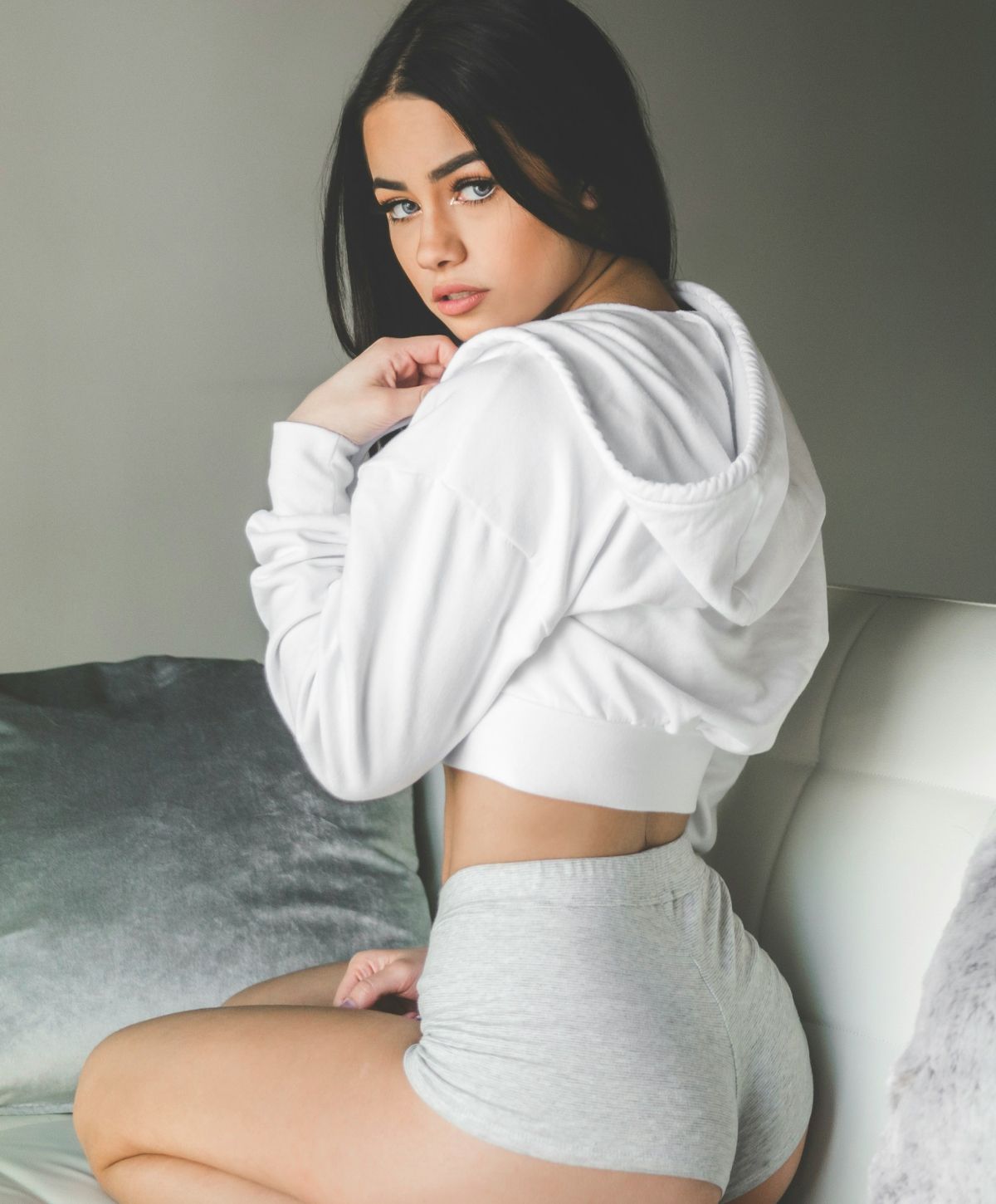 Person sitting in casual outfit on couch.