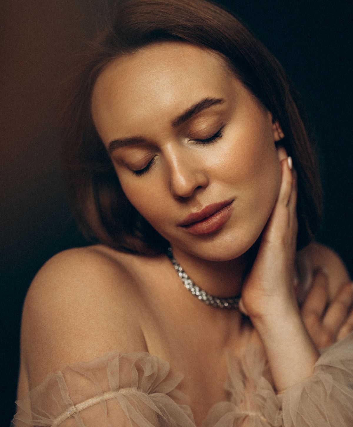 Woman with closed eyes and elegant jewelry.