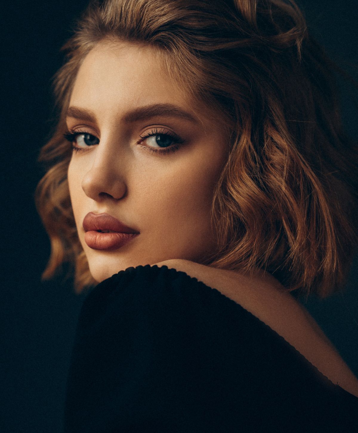 Woman with shoulder-length hair and striking features.