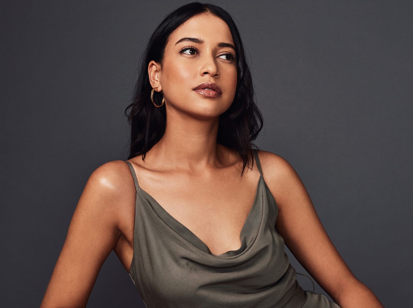 Woman in olive dress with natural makeup.