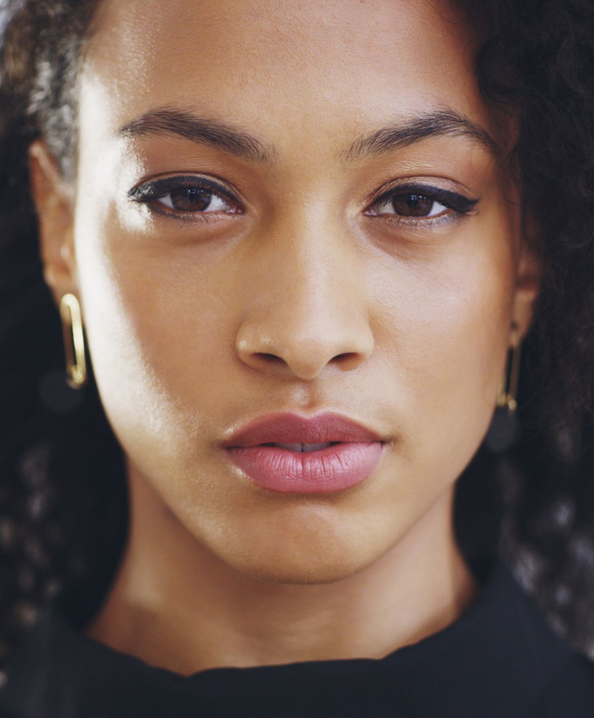 Close-up of a woman's face with curly hair.