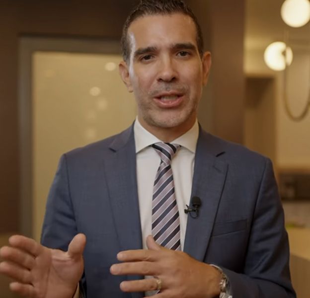 Man in suit speaking with hand gestures.