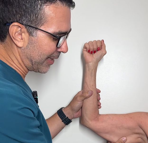Doctor examining a patient's arm and hand.