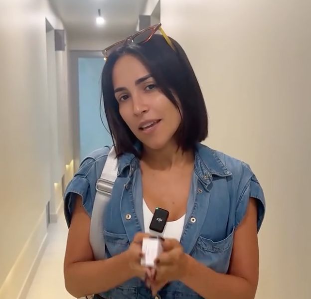Person in denim jacket holding product in hallway.