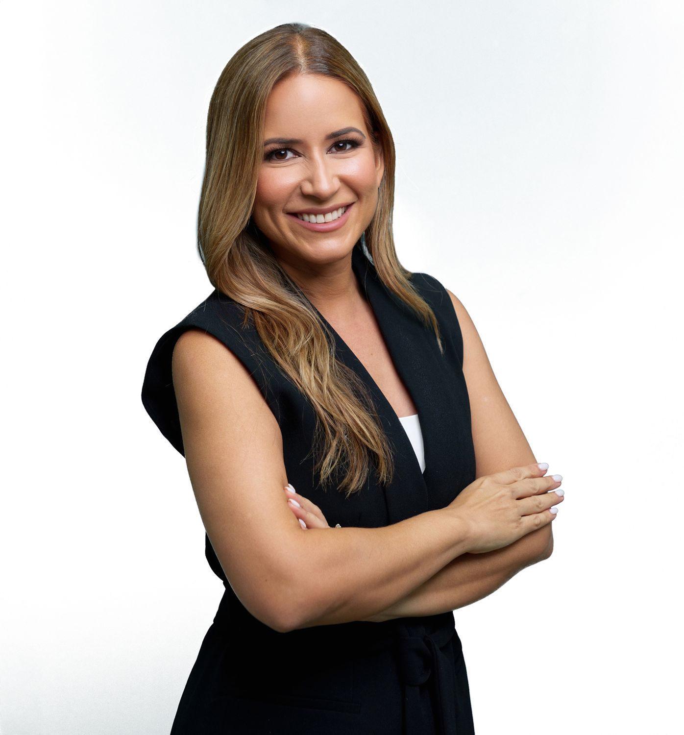 Smiling woman in black attire with crossed arms.