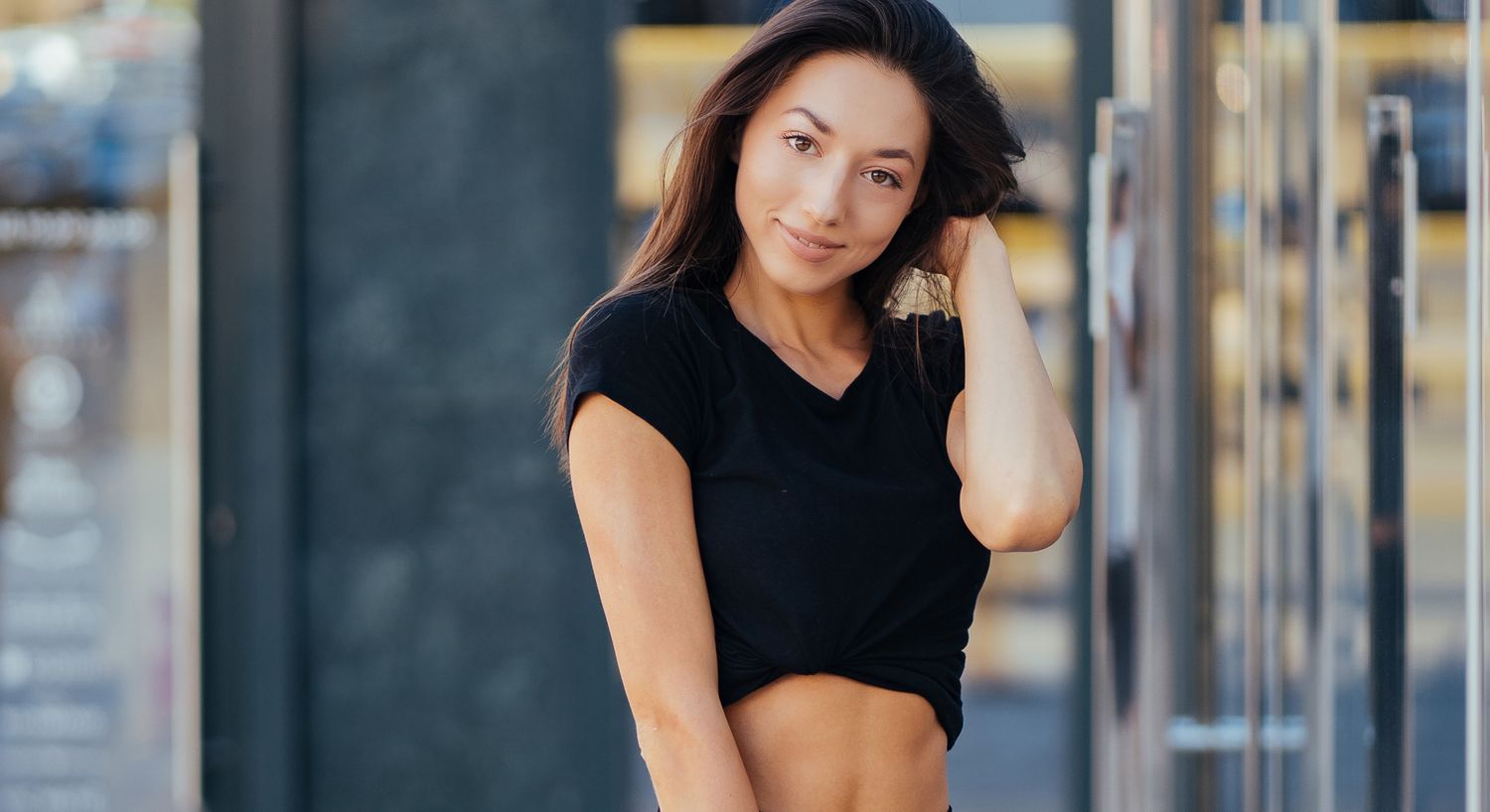 Smiling woman in black shirt outdoors.