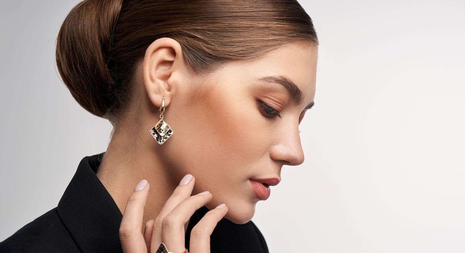Woman with long hair, gold earrings, soft expression.